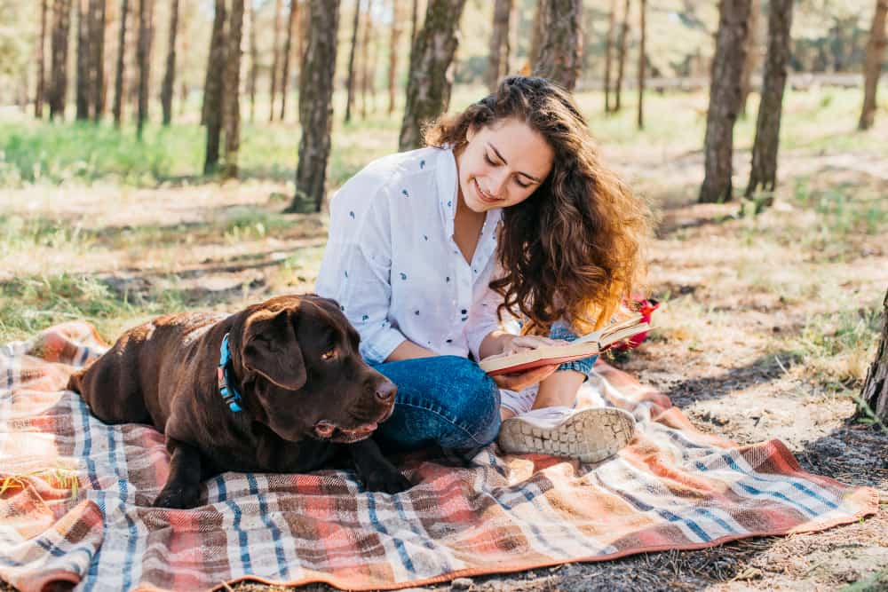 mujer joven de picnic con perro